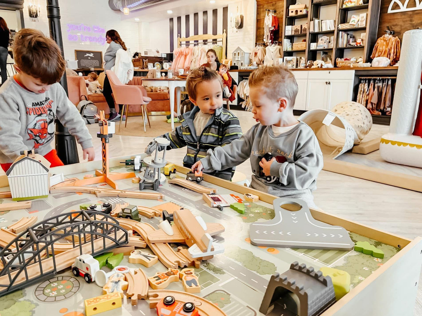 Boys playing with a train table and toy cars in an indoor kids play space in Greensburg, PA at The Trendy Bunny Studio